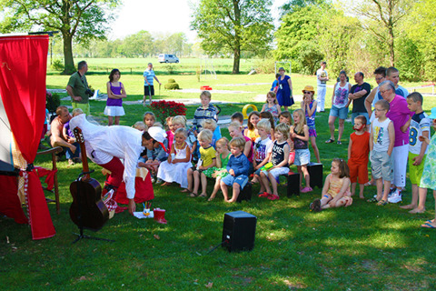 Niños y adultos disfrutan de un espectáculo de marionetas al aire libre en Vakantiepark Sallandshoeve, Overijssel.