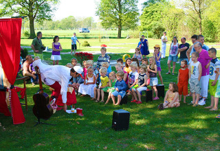 Kinderen en volwassenen volgen een openlucht poppentheater in Vakantiepark Sallandshoeve, Overijssel.