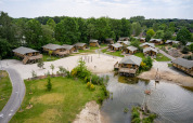 Luftfoto af ferieboliger og telte ved søen på Vakantiepark Sallandshoeve i naturskønne Overijssel, Holland.
