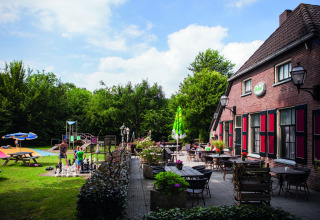 Buitenterras en speeltuin aan Vakantiepark Sallandshoeve, Overijssel, Nederland, zonnige dag.