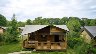 Tienda safari Villatent Ranger con porche en Vakantiepark Sallandshoeve, rodeada de naturaleza en los Países Bajos.