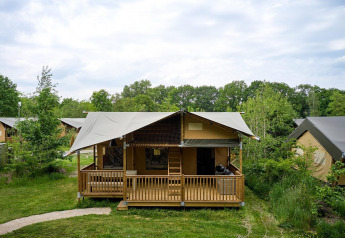 Tenda safari Villatent Ranger con veranda al Vakantiepark Sallandshoeve, circondata dal verde nei Paesi Bassi.