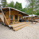 Safari telt Villatent Cottage på Vakantiepark Sallandshoeve i Holland, omgivet af sand og grønne træer.