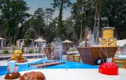 Vandlegeplads med springvand og træstrukturer i ferielandsbyen Hoge Kempen i Limburg, Belgien.