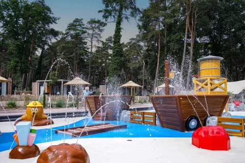 Vandlegeplads med springvand og træstrukturer i ferielandsbyen Hoge Kempen i Limburg, Belgien.