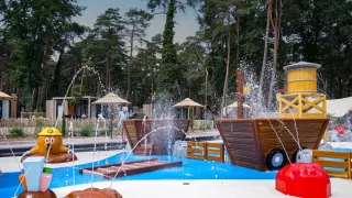Wasserspielplatz mit Springbrunnen und Holzstrukturen im Ferienpark Hoge Kempen in Limburg, Belgien.