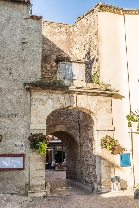 Historische stenen poort bij Camping De l'Olivigne, een vakantiepark in Occitanie, Frankrijk.
