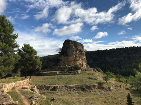 Ruinas de piedra y paisaje en Camping De l'Olivigne en Occitania, Francia, bajo un cielo azul y nubes.