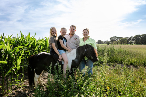 Gezin met twee meisjes op een zwart-witte pony op FarmCamps Breehees, Noord-Brabant, Nederland, zonnige dag.