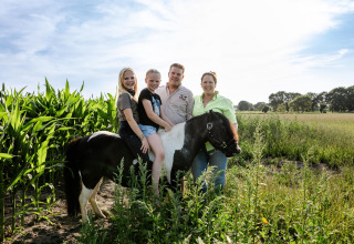 Gezin met twee meisjes op een zwart-witte pony op FarmCamps Breehees, Noord-Brabant, Nederland, zonnige dag.