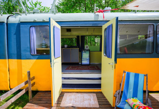 Streetcar Tiny House bei Netl Camping Kallumaan in den Niederlanden mit offenen Türen und Innenansicht.