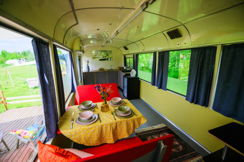 Interieur van tiny house Streetcar bij Netl Camping Kallumaan in Nederland, gedekt voor het diner.