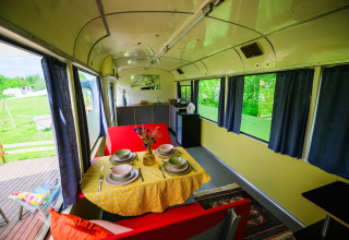 Interno della tiny house Streetcar presso Netl Camping Kallumaan nei Paesi Bassi, apparecchiata per cena.