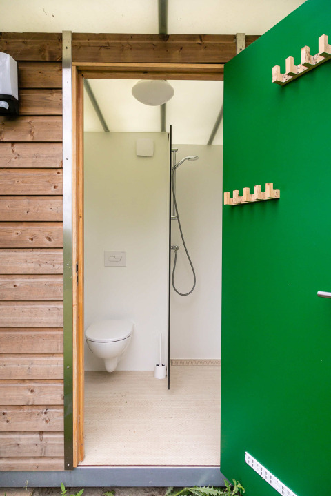 Moderne, kompakt badeværelse med væghængt toilet og bruser i Birdhouse på Netl Camping Kallumaan, Holland.