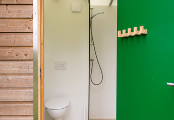 Bagno compatto e moderno con wc sospeso e doccia nel Birdhouse di Netl Camping Kallumaan, Paesi Bassi.