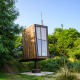 Una tiny house llamada Birdhouse, elevada sobre un pilar y rodeada de vegetación verde y árboles.