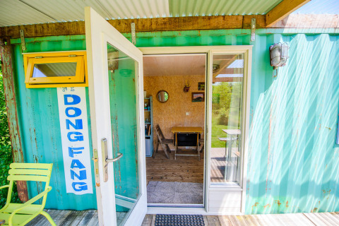 Entrada a una casa pequeña hecha de contenedor en Netl Camping Kallumaan, Países Bajos.