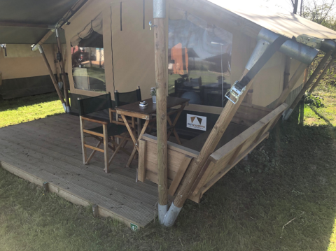 Outdoor terrace with table and chairs at Lodge Compact in Camping de Tolbrug, Netherlands.