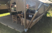 Terrazza esterna con tavolo e sedie al Lodge Compact al Camping de Tolbrug, Paesi Bassi.