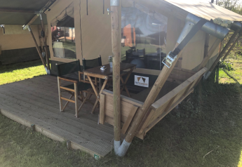 Outdoor terrace with table and chairs at Lodge Compact in Camping de Tolbrug, Netherlands.
