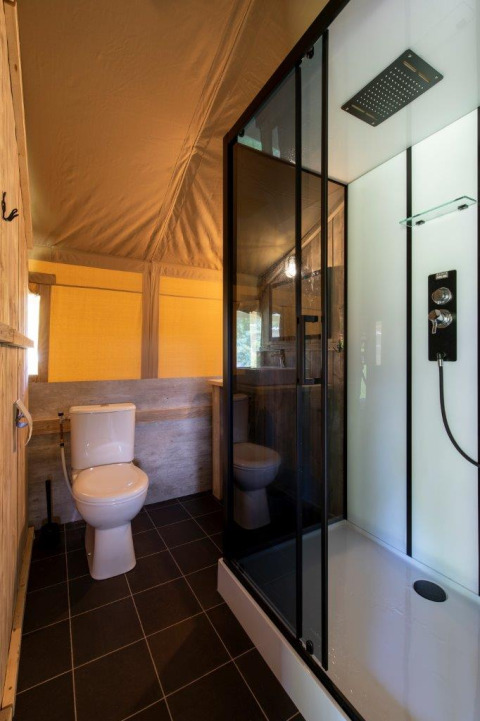 Modernes Badezimmer in einem Safarizelt mit WC und Duschkabine, aufgenommen auf Camping De Rammelbeek, Niederlande.