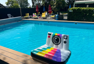 Piscina all'aperto al Camping Emmen, Drenthe, Paesi Bassi, con gonfiabile a forma di fotocamera e lettini.