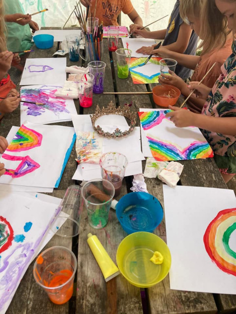 Bambini dipingono arcobaleni colorati a un tavolo di legno al Camping Emmen, villaggio vacanze Drenthe.