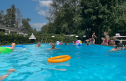 Børn leger og svømmer i udendørs swimmingpool på Camping Emmen feriepark i Drenthe, Holland.