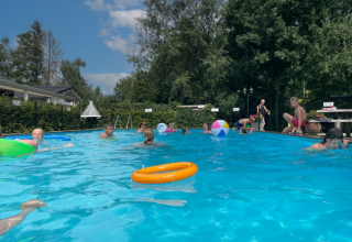 Children playing and swimming in an outdoor pool at Camping Emmen holiday park in Drenthe, Netherlands.