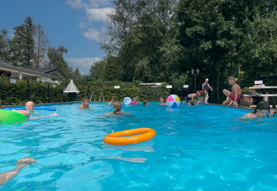 Enfants jouant et nageant dans la piscine extérieure du Camping Emmen, parc de vacances à Drenthe, Pays-Bas.