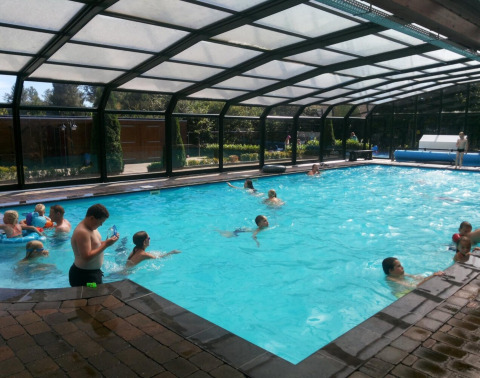 Überdachtes Schwimmbad im Familiepark de Vechtvallei in Overijssel, Niederlande, voller Badegäste.