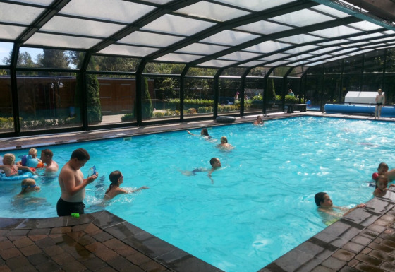 Piscina coperta al Familiepark de Vechtvallei, parco vacanze a Overijssel, Paesi Bassi, con persone che nuotano.