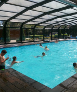 Piscina cubierta en Familiepark de Vechtvallei, parque vacacional en Overijssel, Países Bajos, con familias nadando.