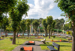 Familiepark Goolderheide con campo de minigolf, piscina, bancos y árboles en un entorno verde en Bélgica.