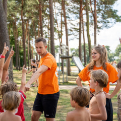 Kinder spielen mit Betreuern im Freizeitpark Familiepark Goolderheide in Limburg, Belgien, an einem sonnigen Tag.