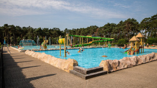 Buitenzwembad in Familiepark Goolderheide, Belgisch Limburg, met glijbanen en speeltoestellen voor kinderen.