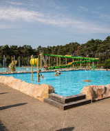 Piscina exterior para familias en Familiepark Goolderheide, Limburg belga, rodeada de toboganes y juegos.