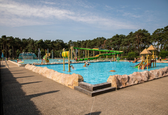 Family-friendly outdoor pool at Familiepark Goolderheide in Belgian Limburg, with slides and play areas.