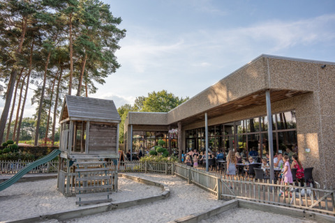 Familiepark Goolderheide: Zona de juegos al aire libre y terraza con visitantes en un parque en Limburg, Bélgica.