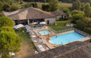 Fugleperspektiv af Camping Fargogne i Occitanie, Frankrig, med swimmingpools og afslappende gæster.