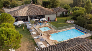 Luchtfoto van Camping Fargogne in Occitanie, Frankrijk, met zwembaden en ontspannen gasten.