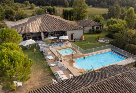 Fugleperspektiv af Camping Fargogne i Occitanie, Frankrig, med swimmingpools og afslappende gæster.