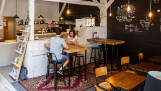 Gemütlicher Cafébereich im Camping Gorishoek in Zeeland, Niederlande mit Holztischen und Wanddeko.