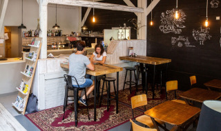 Gemütlicher Cafébereich im Camping Gorishoek in Zeeland, Niederlande mit Holztischen und Wanddeko.