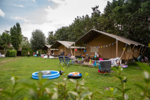 Tiendas familiares y zona de juegos en Camping Gorishoek, parque vacacional en Zelanda, Países Bajos, en verano.