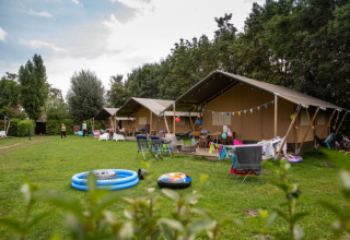 Familievenlige telte og campingområde med legetøj og stole på Camping Gorishoek, Zeeland, Holland, om sommeren.