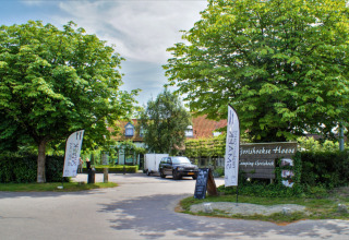 Entrada al parque vacacional Camping Gorishoek en Zelanda, Países Bajos, rodeada de árboles y letreros.