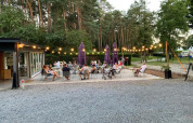 Outdoor dining area at Camping het Swinnenbos, with guests enjoying a summer evening in Belgium.