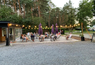 Outdoor dining area at Camping het Swinnenbos, with guests enjoying a summer evening in Belgium.