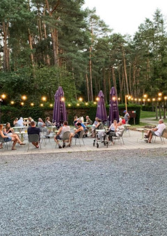 Zona de comedor al aire libre en Camping het Swinnenbos, con huéspedes disfrutando del verano en Bélgica.